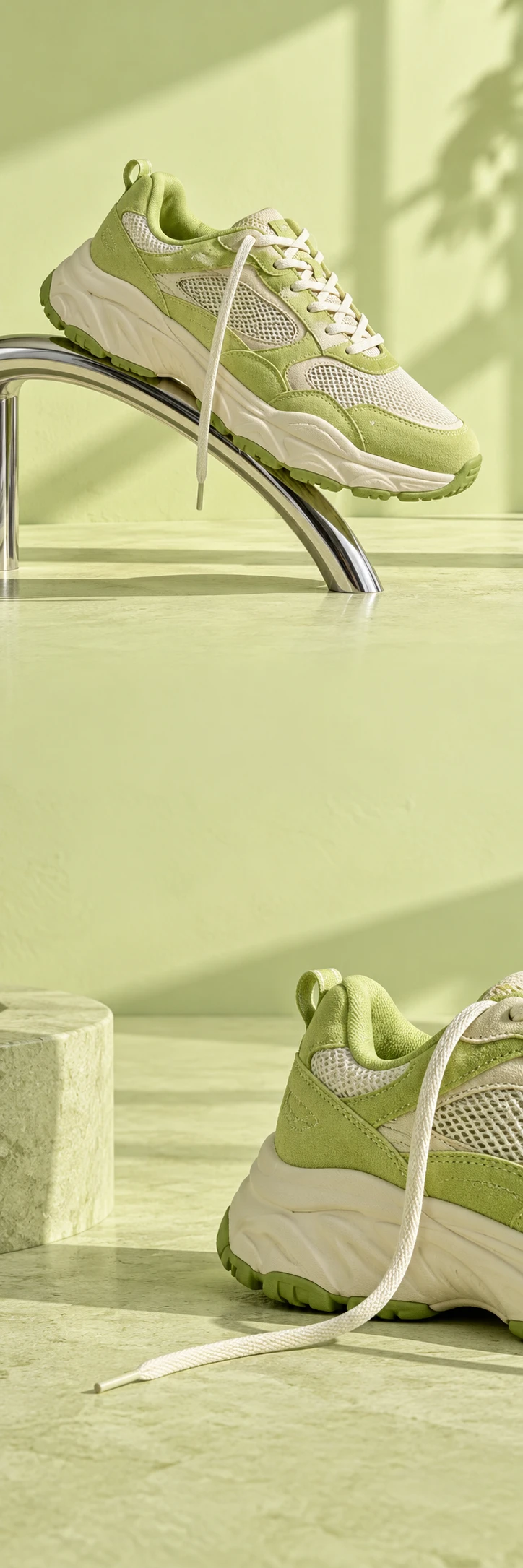 Graphic high fashion sneaker still life: oversized lime and cream suede running sneaker balanced diagonally across a curved chrome rail, pale lime studio wall, long architectural shadow, tactile suede and breathable mesh. Secondary lower closeup of heel and loose laces, same pale lime world. Crisp premium footwear campaign, blank unbranded sides, calm negative space.