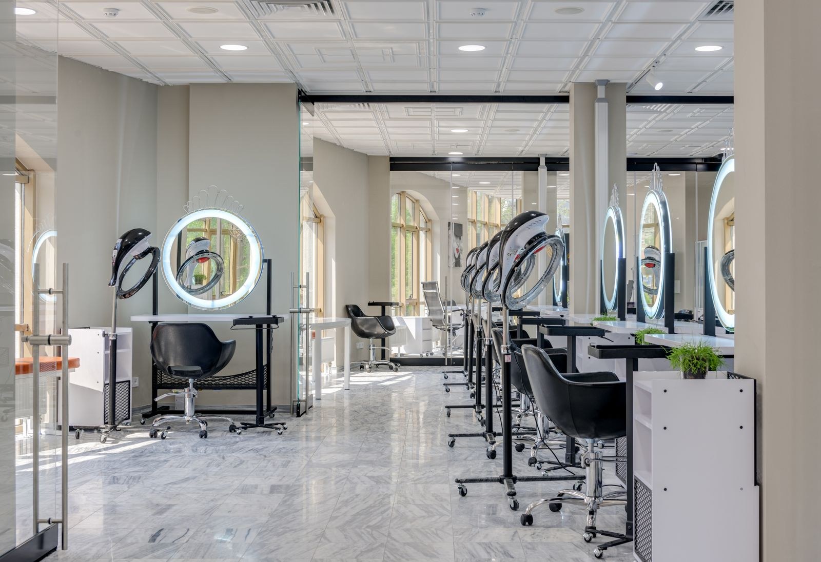 Een lichte salon met spiegels en kappersstoelen